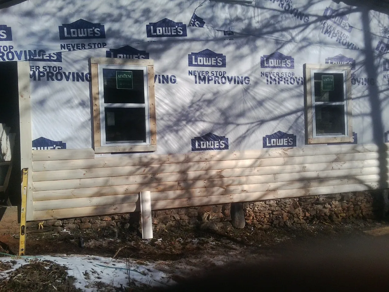 House wrap and new log siding going up on an exterior wall in Thorndale