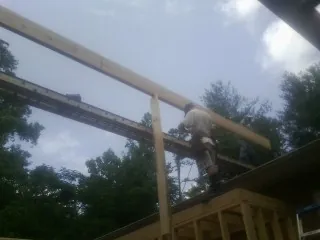 Carpenter setting a ridge beam over a new addition frame — Ice Dam Removal by Roofing Brothers in Thorndale