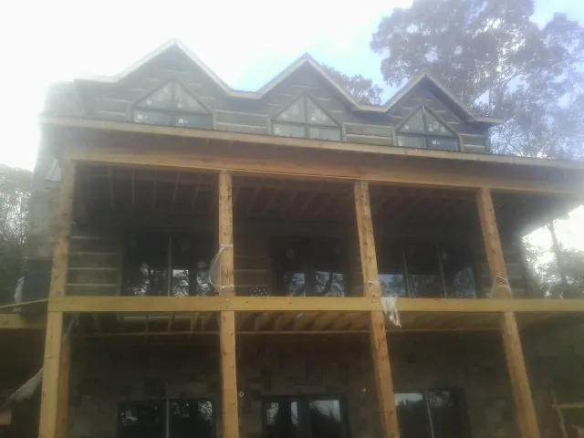 Dormers and porch framing on a large log home under construction — Roof Coating work by our crew in Thorndale